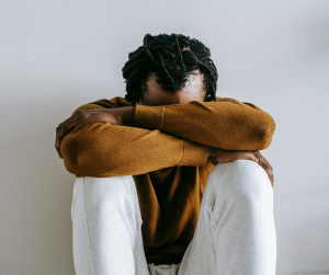 Man with head in arms and lap